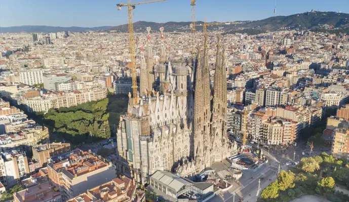 Aerial view of the Sagrada Familia cathedral in Barcelona, showcasing its intricate architecture and surrounding cityscape.