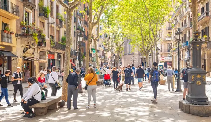A bustling street scene in Barcelona, Spain, filled with pedestrians, shops, and vibrant city life.