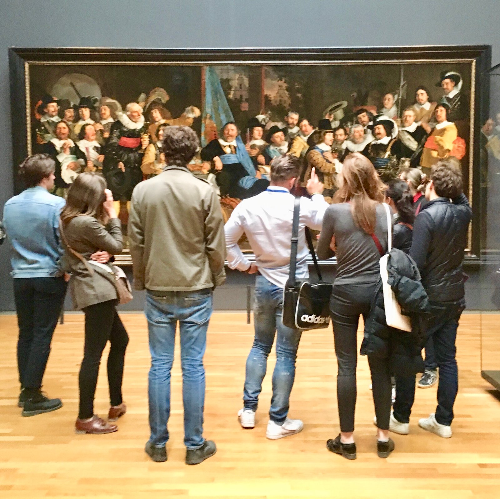 Museum visitors viewing a large Dutch Golden Age group portrait at the Rijksmuseum.