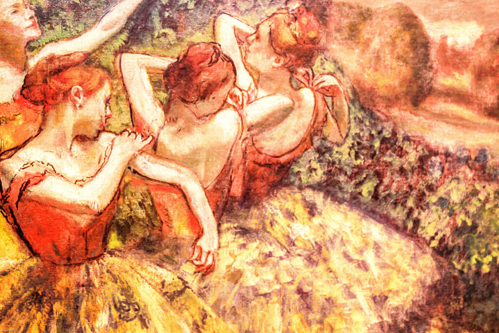 A painting depicting four ballerinas in orange and yellow tutus, with their backs turned, adjusting their costumes. The background features soft, impressionistic foliage and an orange-tinted sky.