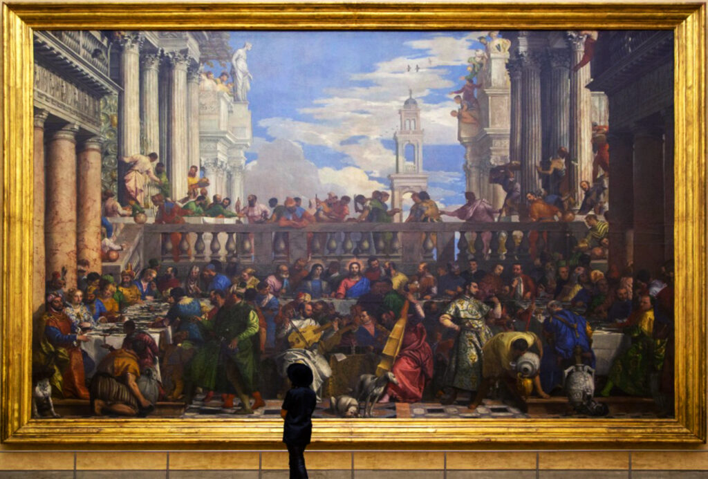 A child stands in front of a large painting framed in gold, depicting a vibrant, historical banquet scene with numerous people, architectural elements, and colorful attire. The painting is rich in detail and fills the wall.